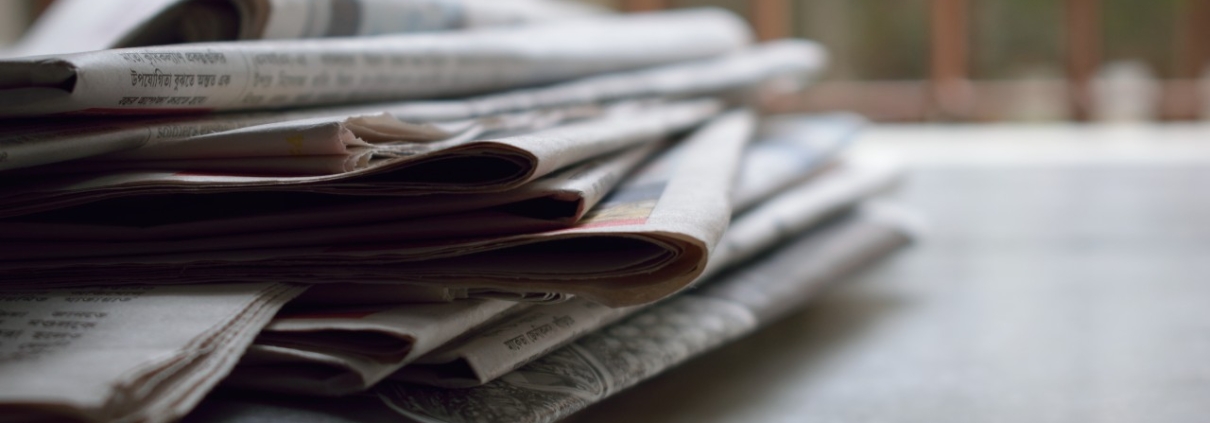 Stack-of-Newspapers-feature-image-1210x423
